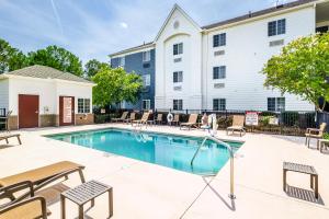 basen z krzesłami i budynkiem w obiekcie Candlewood Suites Savannah Airport by IHG w mieście Savannah