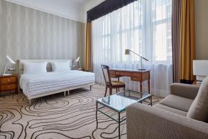 a hotel room with a bed and a couch and a table at Le Méridien Frankfurt in Frankfurt