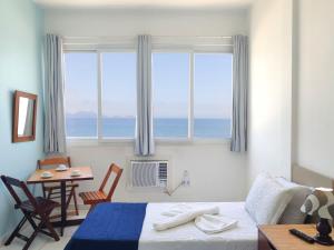 1 dormitorio con cama, mesa y ventana en Studio na Praia Vista Total TC1202, en Río de Janeiro