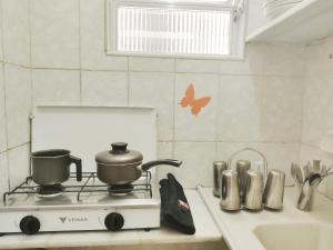 una cocina con fogones con ollas y sartenes. en Studio na Praia Vista Total TC1202, en Río de Janeiro