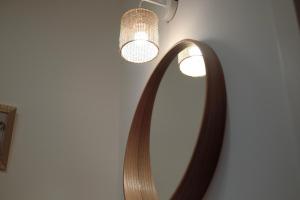 a mirror on a wall with a light and a lamp at JLH Aparts - Just Like Home in Bari