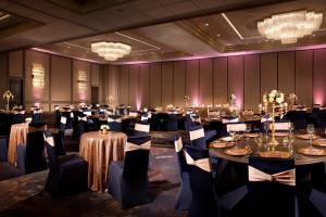 a banquet hall with tables and chairs and chandeliers at Dallas/Fort Worth Airport Marriott in Irving