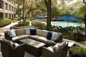 a patio with a couch and chairs next to a pool at Dallas/Fort Worth Airport Marriott in Irving