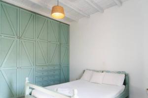 a bedroom with a bed and a green cabinet at House by the Sea in Lefkímmi