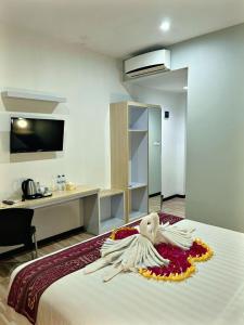 a statue of an angel sitting on top of a bed at Matahari Hotel Labuan Bajo in Labuan Bajo