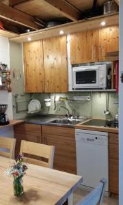 a kitchen with a sink and a microwave at Chalet Hüsli in Giswil