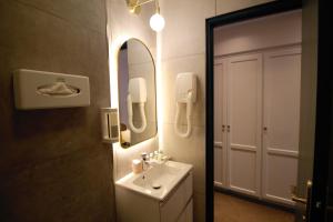 La salle de bains est pourvue d'un lavabo et d'un miroir. dans l'établissement Princesse Caroline, à Paris