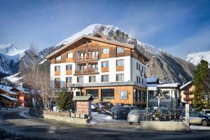 a large building in front of a mountain at Hotel Bernina in Livigno