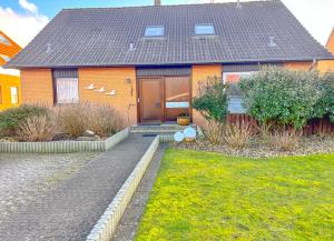 ein Haus mit einer braunen Tür und einem Hof in der Unterkunft Haus Kleemann in Norderney
