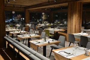 un comedor con mesas y sillas en un restaurante en Hotel Bernina, en Livigno