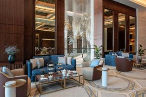 a lobby with blue couches and chairs and a table at The St. Regis Marsa Arabia Island, The Pearl Qatar in Doha