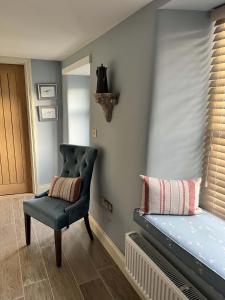 a room with a bed and a chair and a window at Sandpiper in Fowey