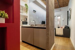 a kitchen with a sink and a red wall at Urbanflat Repubblica Square in Rome