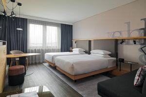 a hotel room with two beds and a table at Frankfurt Airport Marriott Hotel in Frankfurt