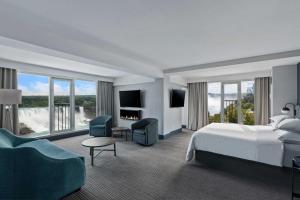 ナイアガラ・フォールズにあるSheraton Fallsview Hotelのベッドと大きな窓が備わるホテルルームです。
