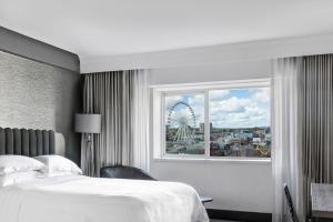 a bedroom with a bed and a window with a ferris wheel at Sheraton Fallsview Hotel in Niagara Falls
