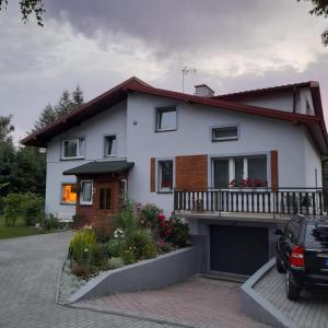 uma casa com um carro estacionado em frente em Agroturystyka Stokrotka em Rymanów-Zdrój