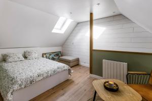 sypialnia z łóżkiem i stołem w obiekcie Le 37 - Maison 2 chambres en bord de mer w mieście Saint-Cast-le-Guildo