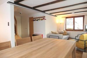 uma cozinha e sala de estar com uma mesa de madeira em Ferienhaus Oberguet em Unterwasser