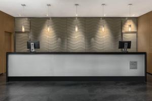 a reception desk with two monitors on top of it at AC Hotel La Finca by Marriott in Pozuelo de Alarcón