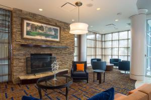 a living room with a fireplace and furniture at Courtyard Columbia Downtown at USC in Columbia