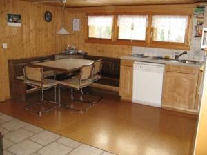 eine Küche mit einem Tisch und Stühlen in der Unterkunft Neuegg in Lütisburg
