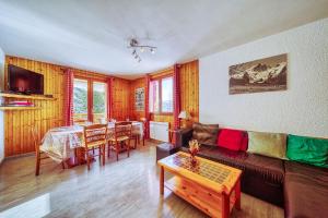 a living room with a couch and a table at Chalet Melody in La Toussuire