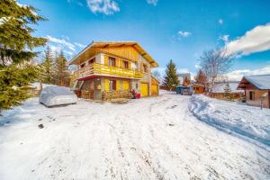 a log home in the snow with a driveway at Chalet Melody in La Toussuire