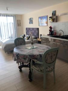 a kitchen with a table and two chairs and a bed at Studio pour 2 personnes à Tonnay Charente in Tonnay-Charente
