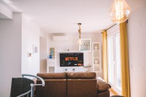 ein Wohnzimmer mit Sofa und Fernseher in der Unterkunft Duplex Victoria Beach Málaga in La Cala del Moral