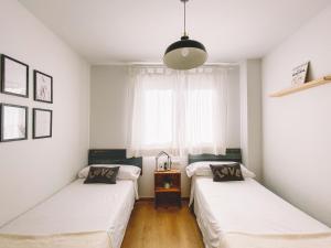 zwei Betten in einem Zimmer mit Fenster in der Unterkunft Duplex Victoria Beach Málaga in La Cala del Moral