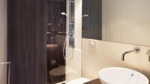 uma casa de banho com um lavatório e um chuveiro em Crowne Plaza Zürich, an IHG Hotel em Zurique