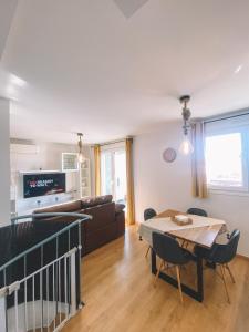 ein Wohnzimmer mit Tisch und Couch in der Unterkunft Duplex Victoria Beach Málaga in La Cala del Moral