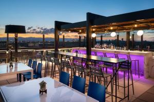 a bar with tables and chairs on a roof at The Jacquard, Autograph Collection in Denver