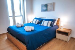 Un dormitorio con una cama azul con toallas. en JLH Aparts - Just Like Home, en Bari