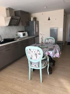 a kitchen with a table and two chairs and a table and a kitchen at Studio pour 2 personnes à Tonnay Charente in Tonnay-Charente