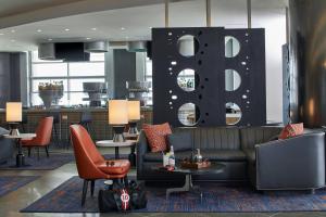 eine Lobby mit einem Sofa und Stühlen sowie einer Bar in der Unterkunft The Daytona, Autograph Collection in Daytona Beach