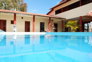 a swimming pool in front of a house at Pousada Brasita in Cumbuco