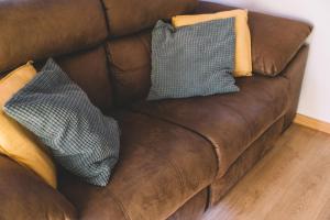 eine braune Couch mit zwei Kissen drauf in der Unterkunft Duplex Victoria Beach Málaga in La Cala del Moral + 34 Fotos
