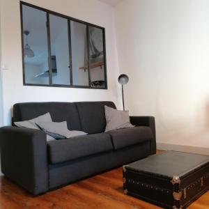 a living room with a couch and a mirror at Dormir à la Rochelle 2 - 50m2 - 1 chambre in La Rochelle
