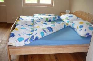 uma cama com um edredão azul e branco em Hof Quadra 