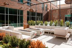 a courtyard with couches and plants in front of a building at Residence Inn by Marriott Greenville Downtown in Greenville