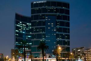 a tall blue building with palm trees in front of it at JW Marriott Hotel Lima in Lima