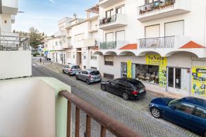 einen Blick von einem Balkon aus auf einer Straße geparkt in der Unterkunft Rustic Old Town - T3 in Albufeira