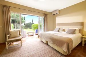 a bedroom with two beds and a large window at Cegonha Country Club in Vilamoura +65 photos