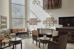 a waiting room with tables and chairs and a large window at Marriott Mena House, Cairo in Cairo