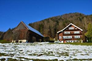 un granero y una casa en un campo con nieve en Breiten, en Brunnadern