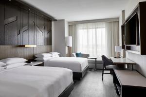 a hotel room with two beds and a television at UNC Charlotte Marriott Hotel & Conference Center in Charlotte