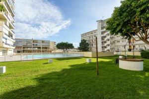 a park with a pool and a tree and buildings at MalagaSuite Carihuela Seaviews in Torremolinos
