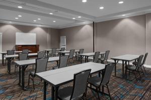Residence Inn Fort Worth Cultural District في فورت وورث: قاعة اجتماعات مع طاولات وكراسي وطاولة بيضاء